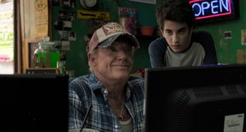 Movie still from “Holy Lands” (2017), directed by Amanda Sthers – An older man and a young boy looking at a computer screen; Close Up shot, Over the shoulder angle