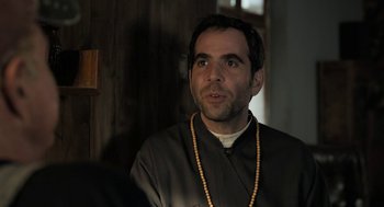 Movie still from “Holy Lands” (2017), directed by Amanda Sthers – A man with a beard wearing a black shirt; Close Up shot, Over the shoulder angle