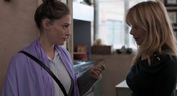 Movie still from “Holy Lands” (2017), directed by Amanda Sthers – Two women looking at each other while holding cell phones in their hands; Medium shot, Over the shoulder angle