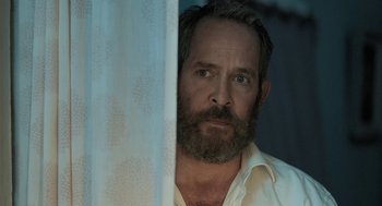 Movie still from “Holy Lands” (2017), directed by Amanda Sthers – A man with a beard is looking at the camera; Close Up shot, Over the shoulder angle