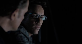 Movie still from “Holy Lands” (2017), directed by Amanda Sthers – A person wearing glasses looking at the camera; Close Up shot, Over the shoulder angle