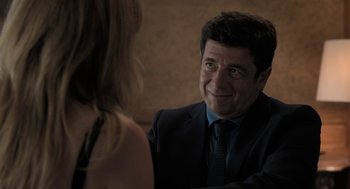 Movie still from “Holy Lands” (2017), directed by Amanda Sthers – A man in a suit and tie talking to a woman; Close Up shot, Over the shoulder angle
