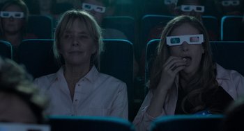 Movie still from “Holy Lands” (2017), directed by Amanda Sthers – Two women sitting in a movie theater wearing 3 d glasses; Medium shot, Low angle
