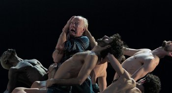 Movie still from “Holy Lands” (2017), directed by Amanda Sthers – An old man is surrounded by shirtless men; Medium shot, High angle