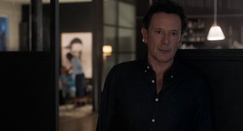 Movie still from “Holy Lands” (2017), directed by Amanda Sthers – A person wearing a black shirt; Medium shot, Over the shoulder angle