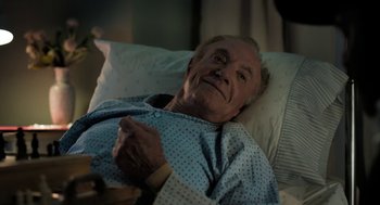 Movie still from “Holy Lands” (2017), directed by Amanda Sthers – An older man laying in a hospital bed; Medium shot, High angle
