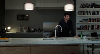 Movie still from “Holy Lands” (2017), directed by Amanda Sthers – A man standing in front of a sink in a kitchen; Wide shot, Over the shoulder angle