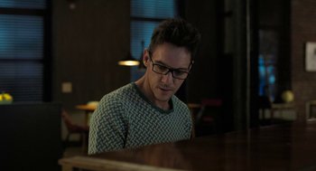 Movie still from “Holy Lands” (2017), directed by Amanda Sthers – A man with glasses is sitting at a piano; Close Up shot, High angle