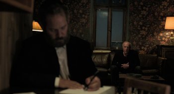Movie still from “Holy Lands” (2017), directed by Amanda Sthers – Two men sitting at a table writing on papers; Medium shot, Over the shoulder angle