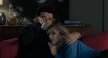 Movie still from “Holy Lands” (2017), directed by Amanda Sthers – A man and a woman holding a cell phone together; Medium shot, High angle