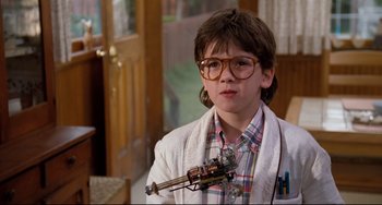 Movie still from “Honey, I Shrunk the Kids” (1989), directed by Joe Johnston – A young boy wearing glasses and holding a toy gun; Close Up shot, Low angle
