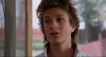 Movie still from “Honey, I Shrunk the Kids” (1989), directed by Joe Johnston – A young man with long brown hair looking at the camera; Close Up shot, Low angle