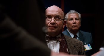 Movie still from “Honey, I Shrunk the Kids” (1989), directed by Joe Johnston – A man in a suit and bow tie looking at the camera; Close Up shot, Over the shoulder angle