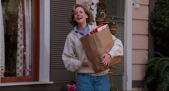 Movie still from “Honey, I Shrunk the Kids” (1989), directed by Joe Johnston – A woman holding a brown paper bag and laughing; Medium shot, Low angle
