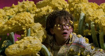 Movie still from “Honey, I Shrunk the Kids” (1989), directed by Joe Johnston – A young boy is surrounded by a bunch of yellow flowers; Medium shot, High angle