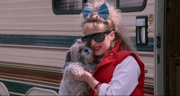 Movie still from “Honey, I Shrunk the Kids” (1989), directed by Joe Johnston – A woman holding a dog in front of a trailer; Medium shot, High angle