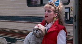 Movie still from “Honey, I Shrunk the Kids” (1989), directed by Joe Johnston – A woman holding a dog in her arms outside; Medium shot, Low angle