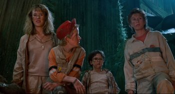 Movie still from “Honey, I Shrunk the Kids” (1989), directed by Joe Johnston – A group of people standing next to each other in a forest; Medium shot, Low angle