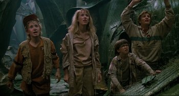 Movie still from “Honey, I Shrunk the Kids” (1989), directed by Joe Johnston – A group of people standing next to each other in a forest; Medium shot, Low angle