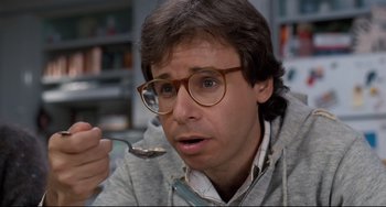 Movie still from “Honey, I Shrunk the Kids” (1989), directed by Joe Johnston – A man with glasses is holding a spoon in his hand; Close Up shot, Over the shoulder angle