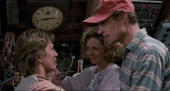 Movie still from “Honey, I Shrunk the Kids” (1989), directed by Joe Johnston – A group of people standing next to each other in front of a clock; Medium shot, Over the shoulder angle