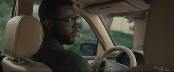 Movie still from “Us” (2019), directed by Jordan Peele – A man sitting in the driver's seat of a car; Close Up shot, Over the shoulder angle