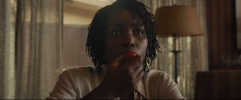 Movie still from “Us” (2019), directed by Jordan Peele – A person eating a piece of food in a room; Close Up shot, Over the shoulder angle