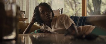 Movie still from “Us” (2019), directed by Jordan Peele – A person sitting at a table with their hand on his head; Close Up shot, Over the shoulder angle