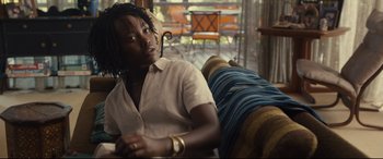 Movie still from “Us” (2019), directed by Jordan Peele – A woman sitting on a couch in a room; Medium shot, Over the shoulder angle