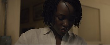 Movie still from “Us” (2019), directed by Jordan Peele – A person wearing a white shirt; Close Up shot, Over the shoulder angle