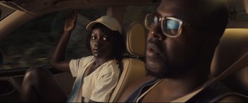 Movie still from “Us” (2019), directed by Jordan Peele – A man and a woman sitting in the back seat of a car; Close Up shot, Over the shoulder angle