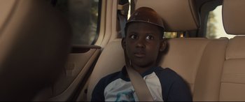 Movie still from “Us” (2019), directed by Jordan Peele – A young man sitting in a car wearing a hat; Close Up shot, Over the shoulder angle