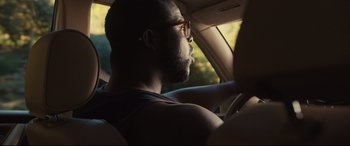 Movie still from “Us” (2019), directed by Jordan Peele – A man sitting in the driver's seat of a car; Close Up shot, Over the shoulder angle