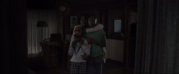 Movie still from “Us” (2019), directed by Jordan Peele – A group of people standing next to each other in a living room; Medium shot, High angle