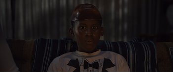 Movie still from “Us” (2019), directed by Jordan Peele – A young boy wearing a bow tie and a hat; Close Up shot, Low angle