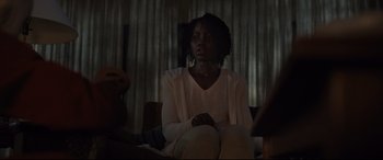Movie still from “Us” (2019), directed by Jordan Peele – A woman sitting on a chair in a room; Medium shot, Over the shoulder angle
