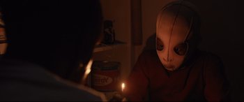 Movie still from “Us” (2019), directed by Jordan Peele – A person with a candle in a room; Close Up shot, Over the shoulder angle