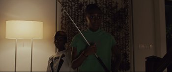 Movie still from “Us” (2019), directed by Jordan Peele – A young man and a woman are holding a sword; Medium shot, Low angle