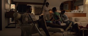 Movie still from “Us” (2019), directed by Jordan Peele – A group of people sitting in a living room; Medium shot, High angle