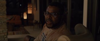 Movie still from “Us” (2019), directed by Jordan Peele – A person wearing glasses and a sweater; Close Up shot, Over the shoulder angle