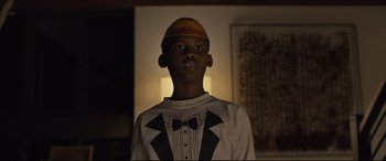 Movie still from “Us” (2019), directed by Jordan Peele – A young boy wearing a bow tie and a shirt; Close Up shot, Low angle