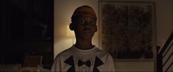 Movie still from “Us” (2019), directed by Jordan Peele – A young boy wearing a brown hat and a white shirt; Close Up shot, Low angle