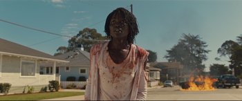 Movie still from “Us” (2019), directed by Jordan Peele – A person with blood all over their face and neck; Medium shot, Low angle