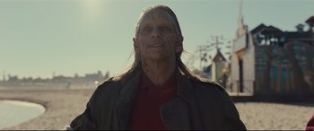 Movie still from “Us” (2019), directed by Jordan Peele – A man with long black hair and a red shirt; Close Up shot, Over the shoulder angle