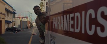 Movie still from “Us” (2019), directed by Jordan Peele – A man and a boy leaning against a ambulance; Medium shot, Low angle
