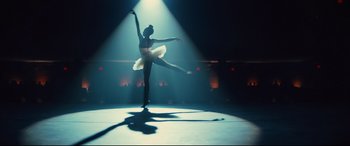 Movie still from “Us” (2019), directed by Jordan Peele – A woman in a white dress is dancing on a stage; Wide shot, Low angle