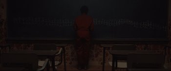 Movie still from “Us” (2019), directed by Jordan Peele – A person standing in front of a chalkboard; Extreme Wide shot, Over the shoulder angle
