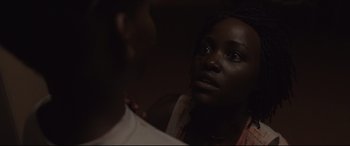 Movie still from “Us” (2019), directed by Jordan Peele – A woman looking at a man in a dark room; Close Up shot, Over the shoulder angle