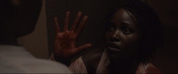 Movie still from “Us” (2019), directed by Jordan Peele – A young woman holding up her hand with blood all over it; Close Up shot, High angle