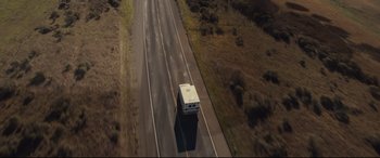 Movie still from “Us” (2019), directed by Jordan Peele – An aerial view of a bus driving down the road; Extreme Wide shot, Overhead angle